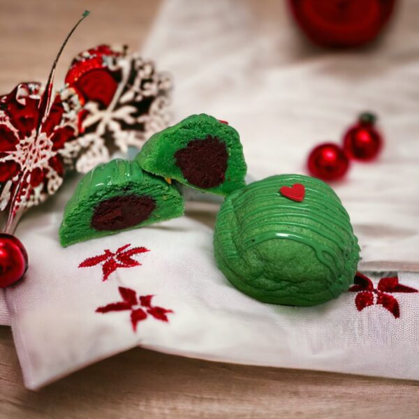 A green cake is sitting on top of a white cloth.