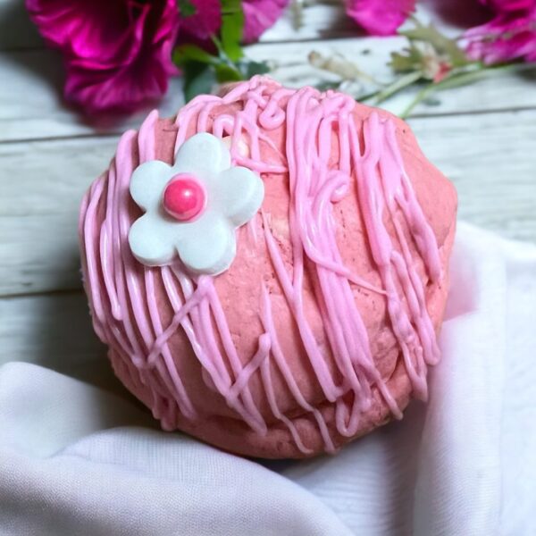 A pink ball with white flower on top of it.