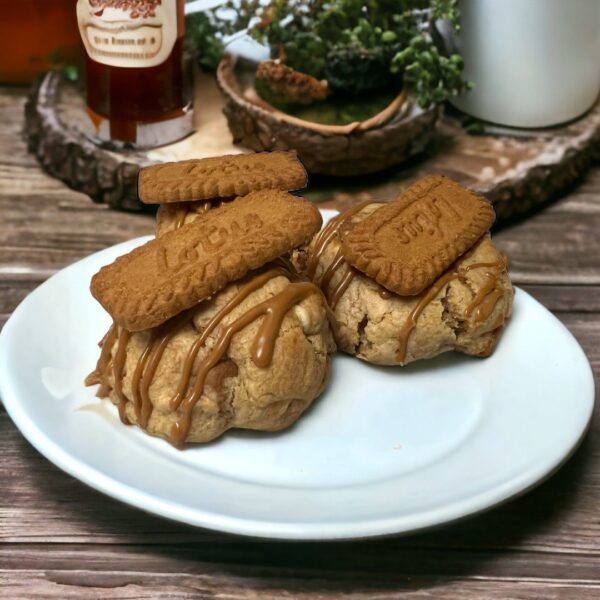 Two cookies on a plate with some peanut butter and jelly.