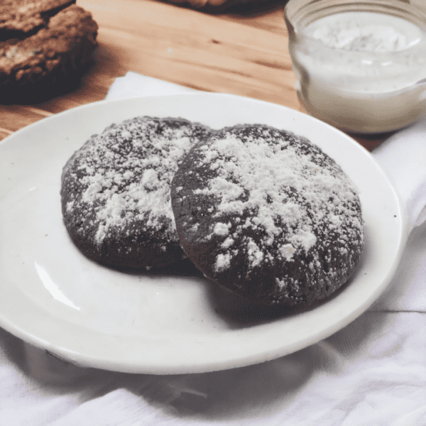 A white plate topped with two chocolate cookies.