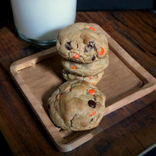 A wooden tray holding cookies and milk on top of a table.