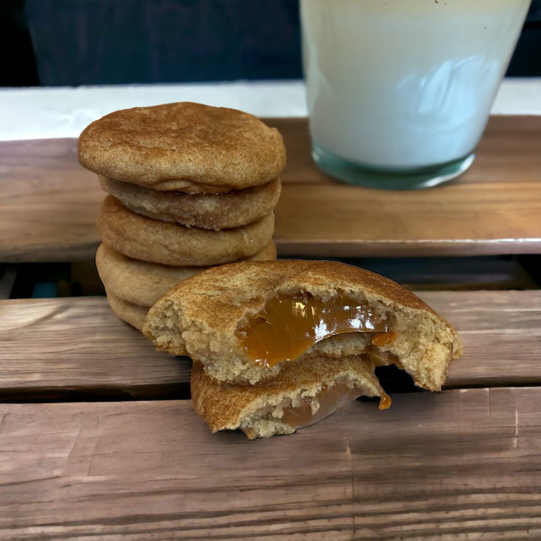 A wooden table with some cookies and milk