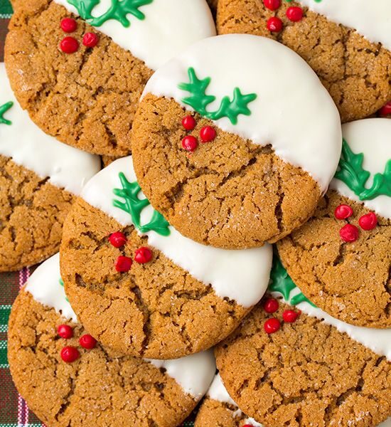 A pile of cookies with white frosting and red berries.