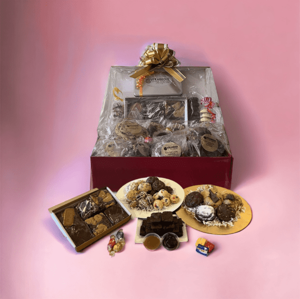 A box of cookies and chocolates on top of a pink background.