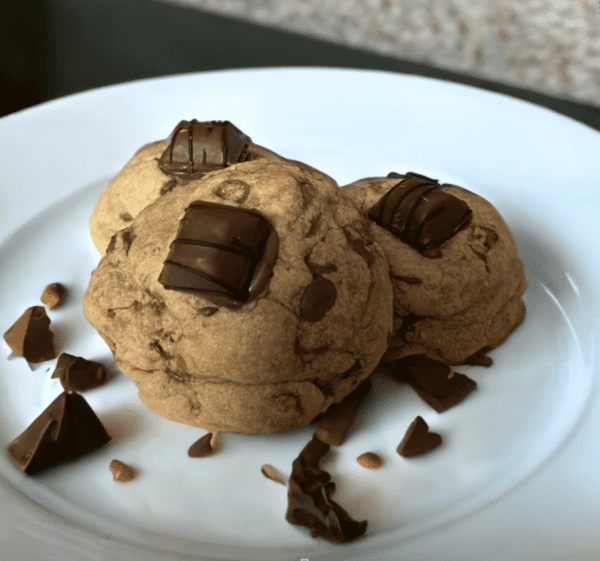 Two cookies on a plate with chocolate chips.