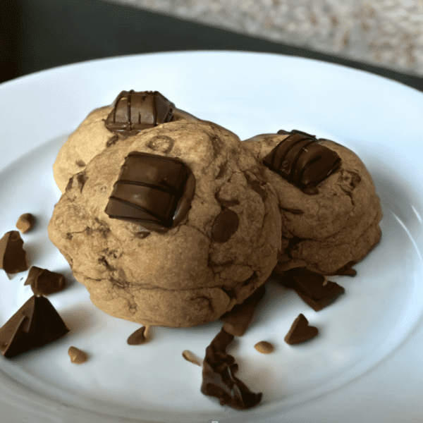 Two cookies on a plate with chocolate chips.