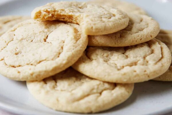 A pile of cookies sitting on top of a white plate.