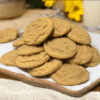A pile of cookies on top of a wooden board.