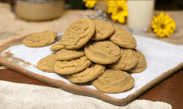 A pile of cookies on top of a wooden board.