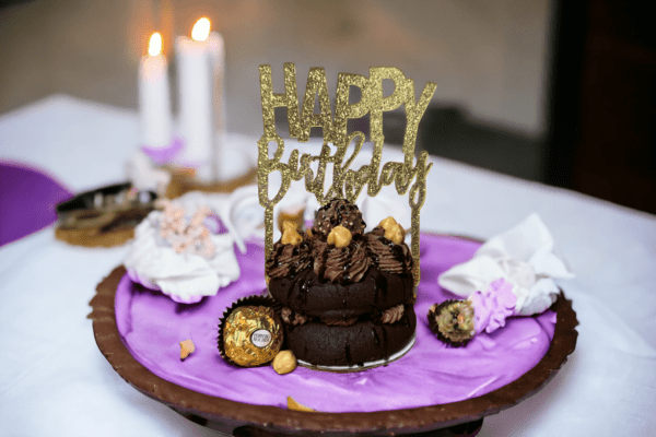 A chocolate cake with happy birthday on top.