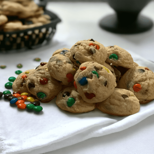 A plate of cookies with m & ms on top.