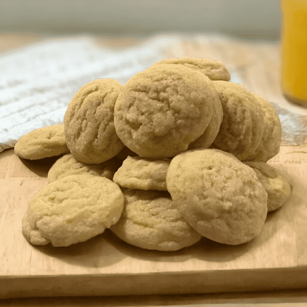 A pile of cookies on top of a wooden board.