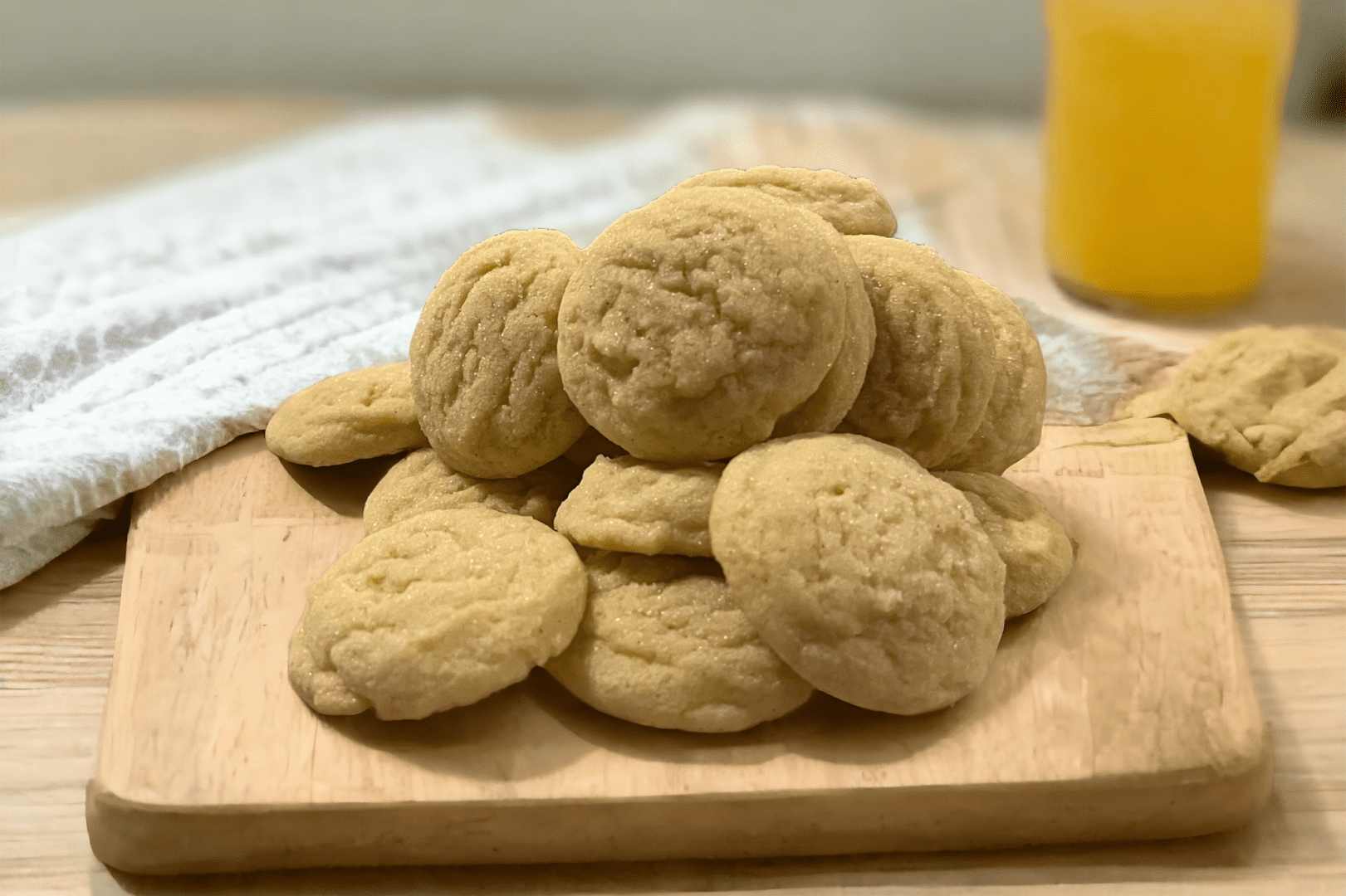 A pile of cookies on top of a wooden board.