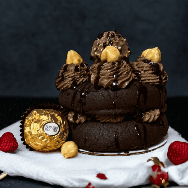 A chocolate cake with fruit and a ferrero rocher.