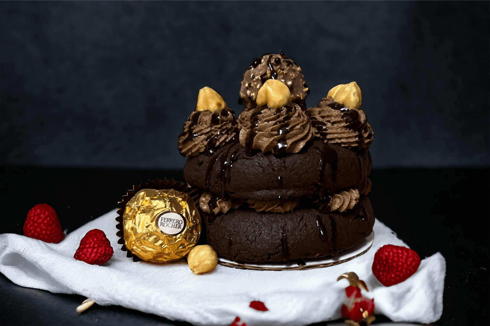 A chocolate cake with fruit and a ferrero rocher.