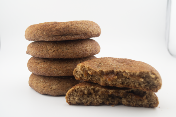 A stack of cookies with one broken in front.